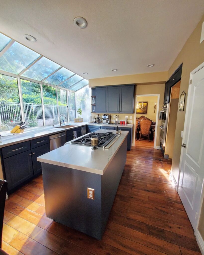 Mission Viejo kitchen remodel featuring blue shaker cabinets, new countertops, and walnut shelves.